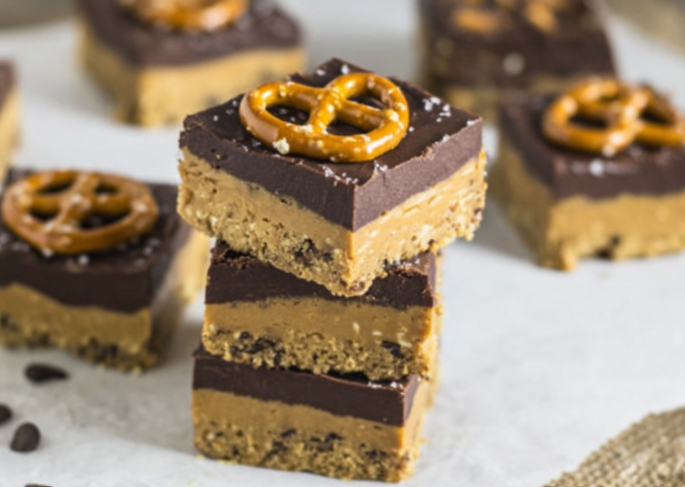 sweet and salty no bake dessert bars stacked with chocolate and pretzels